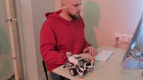 Close Up of an Young Bearded Man That is Learning Robotics Lessons Using Computer