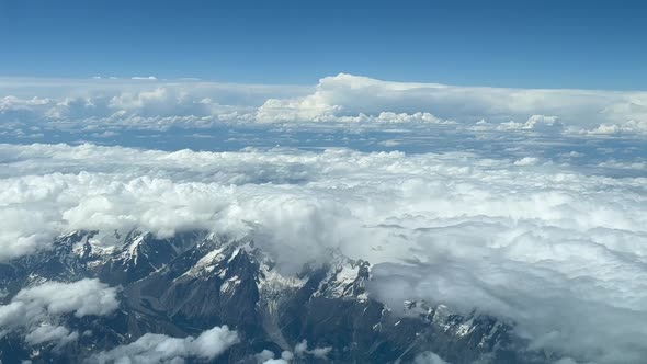 Aerial jet view. Pilot pov of the ilatian Alps, partially covered with snow and some white clouds, w