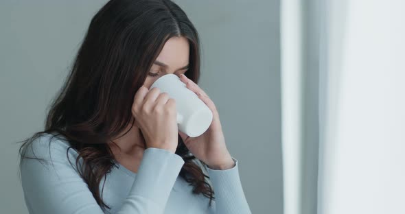 Upset Worried Young Woman, Looking Out of Window, Holding Cup of Hot Tea, Slow Motion