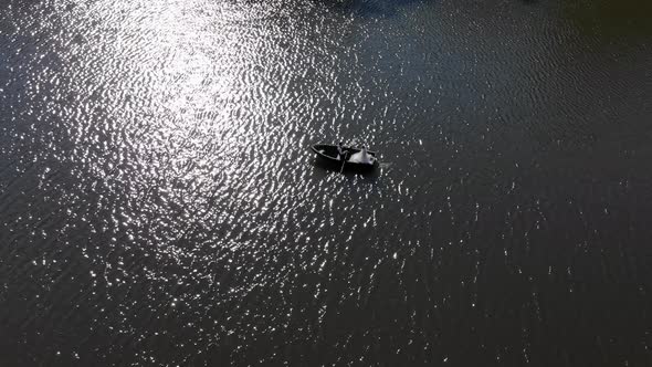 Boat with Brides on the Background of the Fabulous Glare of the Sun Which is Reflected in the Water