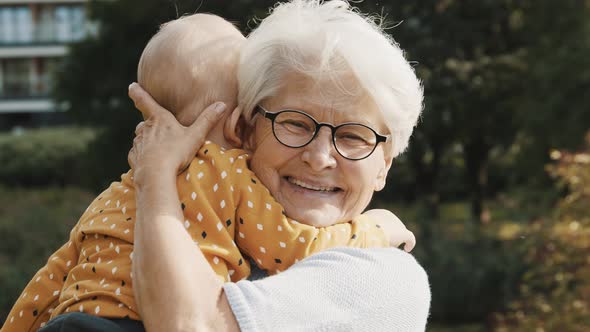 Happy Grandmother Embracing Her Grandson in Nature. Family Bonding and Emotions