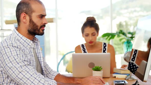 Male executive working on laptop at desk