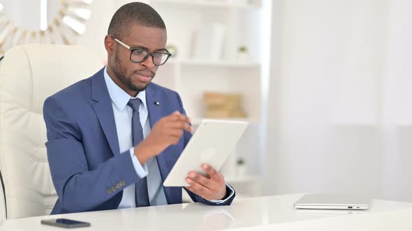 Professional Young African Businessman Using Tablet in Office 