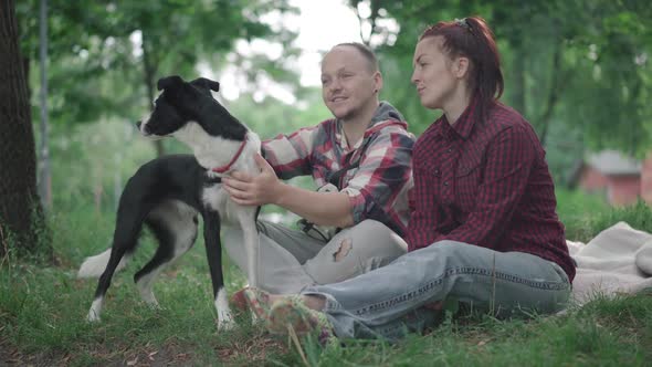 Relaxed Man and Woman Sitting on Blanket in Park on Summer Morning and Talking, Portrait of Cheerful