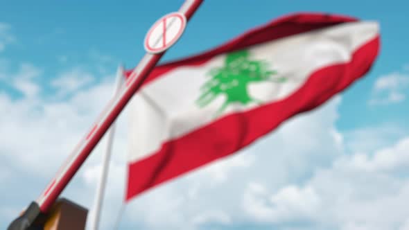 Closing Barrier with STOP CORONAVIRUS Sign Against the Lebanese Flag