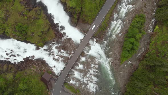 Cars driving over bridge in Norwegian highlands, Latefossen Waterfall, aerial