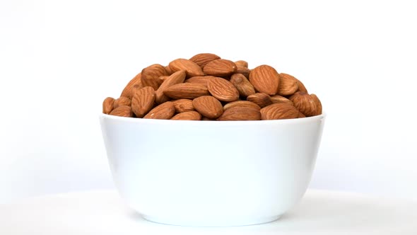 Almonds in bowl rotating on white background