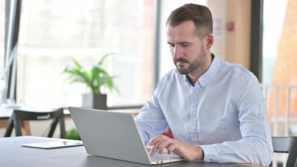 Serious Young Man Closing Laptop and Going Away 