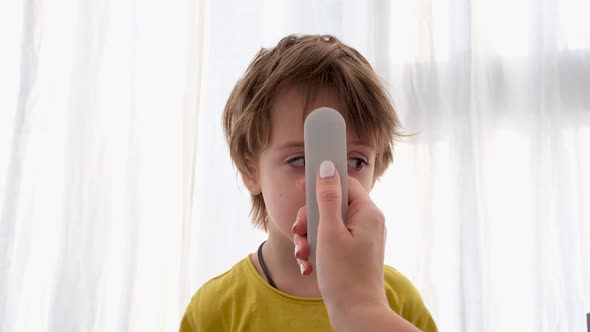 Using Infrared Thermometer To Measure Child's Body Temperature