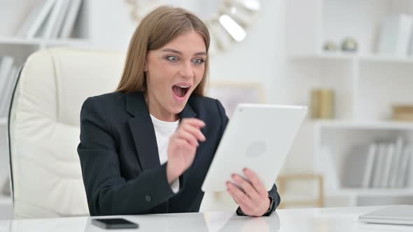Excited Businesswoman Celebrating Success on Tablet 
