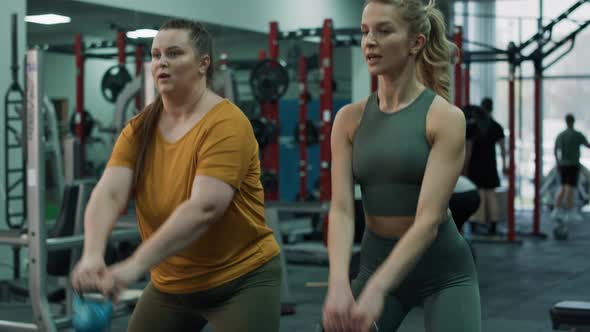 Caucasian woman with overweight doing training with fitness instructor at the gym. Shot with RED hel