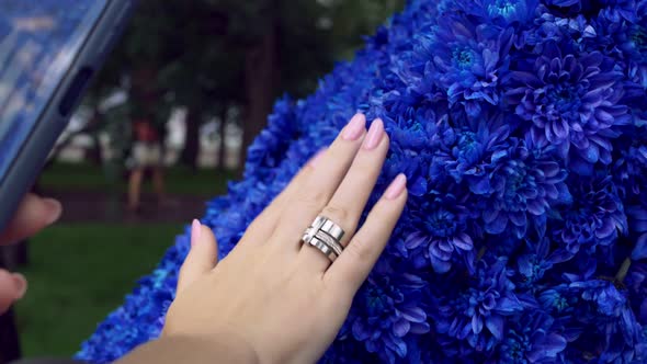 A Girl Takes a Photo on a Smartphone of Her Hand with a Beautiful Manicure Against a Background of