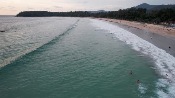 Surfers Catch Waves at Sunset