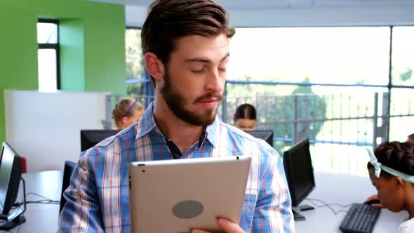 Teacher using digital tablet in classroom