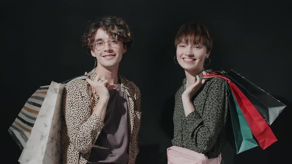 Portrait of Young Happy Man and Woman with Shopping Bags