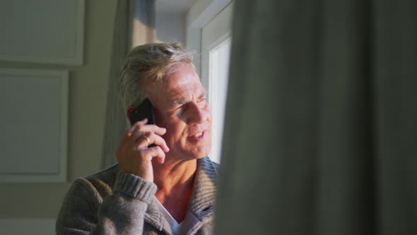 Animation of happy caucasian senior man using smartphone at home