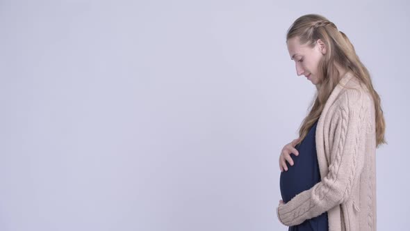 Profile View of Happy Young Pregnant Woman Looking at Camera