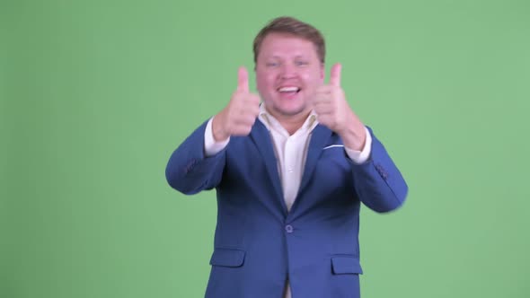 Happy Overweight Bearded Businessman Giving Thumbs Up and Looking Excited