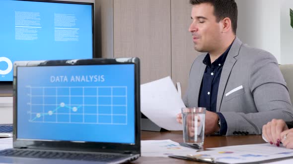 Businessman in Meeting Room Talking with Her Colleagues