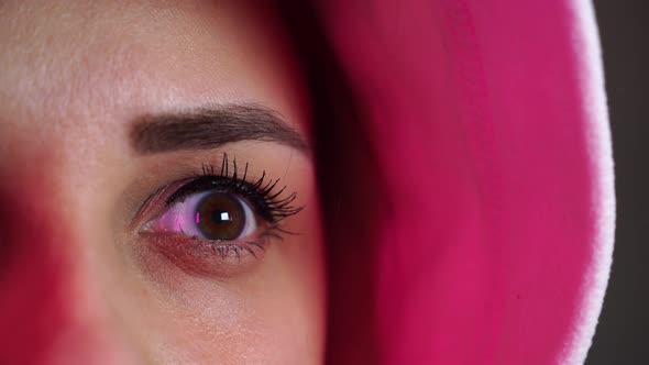 Portrait of Young Woman in Hood Blinking and Looking Away