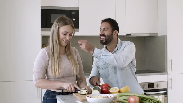 Happy Young Couple Cooking Salad Together