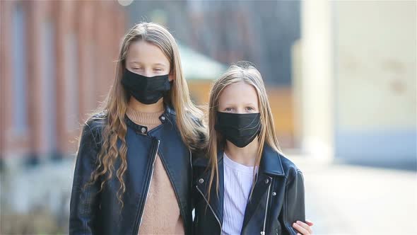 Girls Wearing a Mask on a Background of a Modern Building,