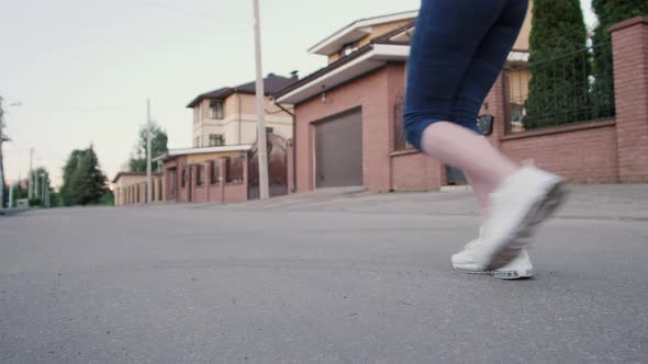 Close Up Woman Legs Running on Concrete Footpath at Public Park with Sunlight in the Background