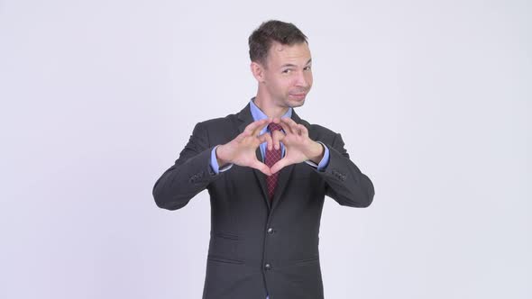 Studio Shot of Happy Businessman with Hand Heart Gesture
