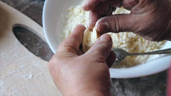 Mature Female Hands Making Dumplings with Cheese at Home Kitchen