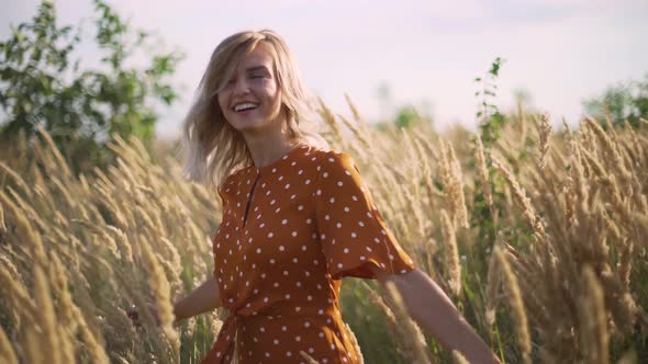 Attractive Fun Hippie Blonde Woman in the Field at Sunset Having Good Time Outdoors