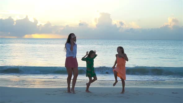 Adorable Little Girls and Young Mother Having Fun on White Beach, SLOW MOTION