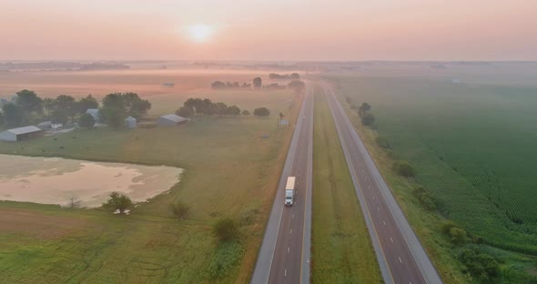 Aerial View of Beautiful Sunrise Highway That Separates the Morning Fields with the Dawn Fog