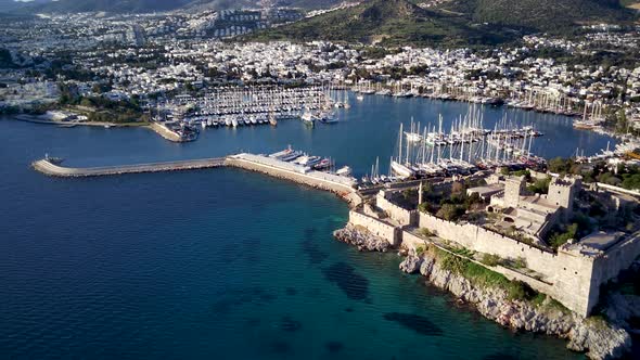 View from drone on full of yachts Bodrum harbour and ancient Kalesi castle in Mugla in Turkey