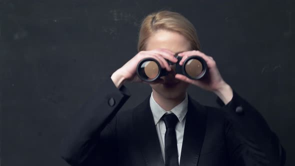 businesswoman in a classic business suit with binoculars