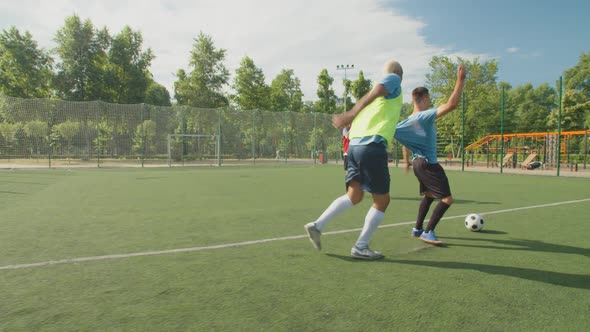 Side View of Soccer Defender Pulling Shirt Striker on Football Pitch