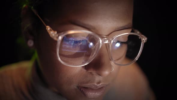 Closeup of the Reflection of the Computer Screen on the Glasses of a Woman Working with a Laptop in