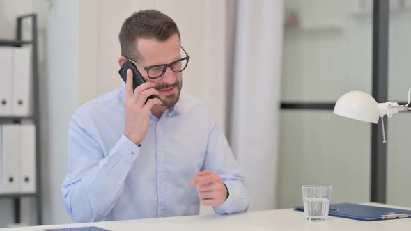 Middle Aged Man Angry on Smartphone at Work