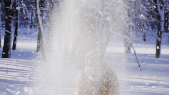 Happy Young Man Throwing Snow Up in Front of Camera