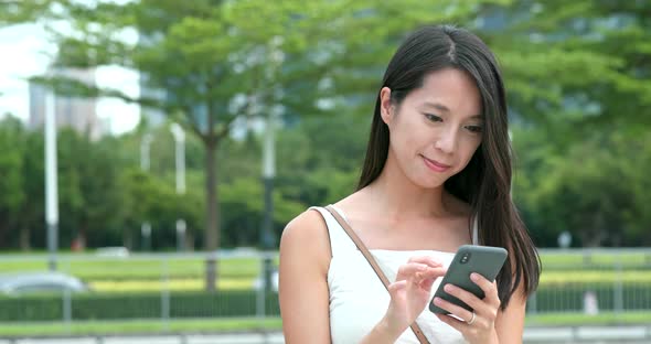 Asian woman use of mobile phone in city