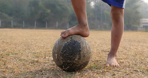 Old Soccer Ball With Rural Boy's Feet alt