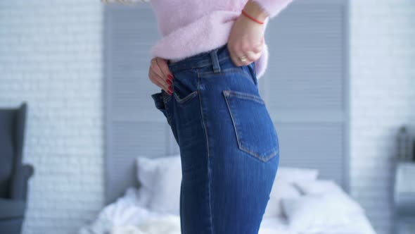 Adult Woman Trying To Zip Up Tight Jeans at Home