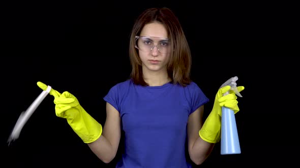 A Young Woman Twists a Toilet Brush on Her Finger and Sprinkles Water From a Spray Bottle