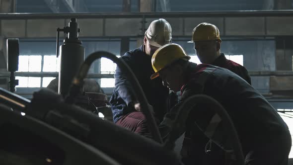 Industrial Plant Workers Discussing Machine Equipment