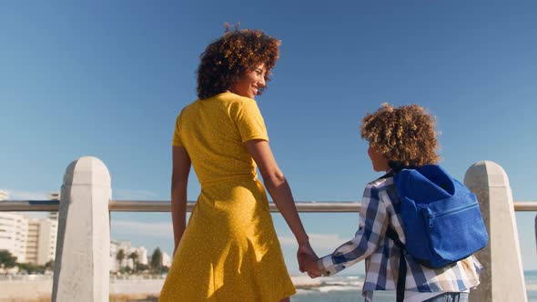 Mother and son holding hands at beach