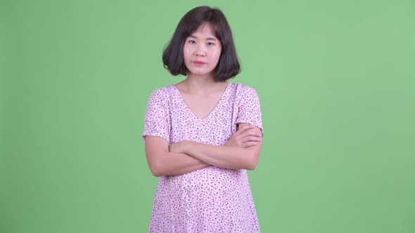 Stressed Asian Pregnant Woman Looking Angry with Arms Crossed