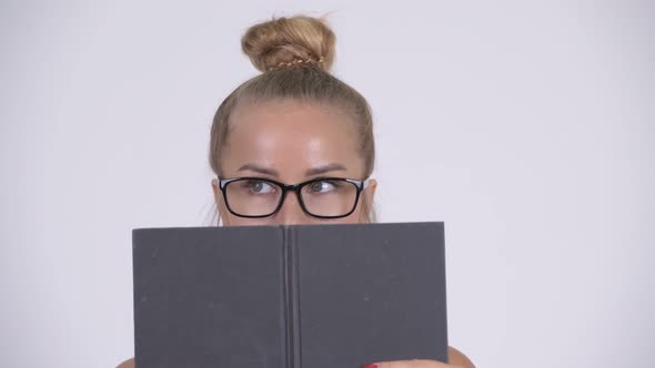 Young Beautiful Blonde Woman Covering Face with Book