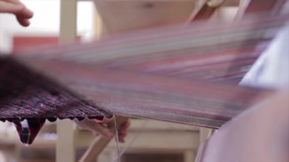 Artisan weaves a rug