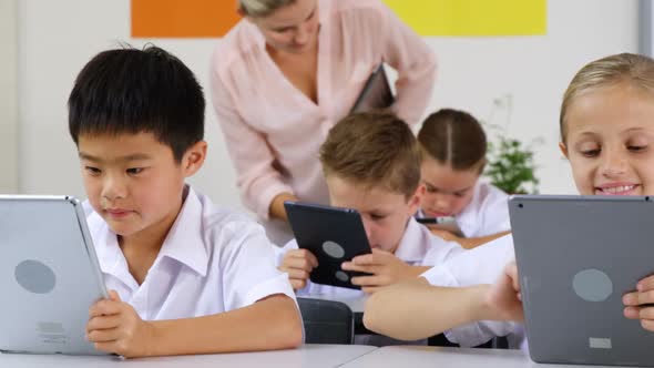 Schoolkids using digital tablet in classroom