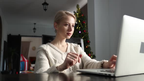 Woman working with laptop computer at home in Christmas time