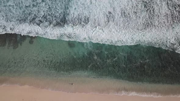 Aerial Top View of Ocean Waves Break on a Beach